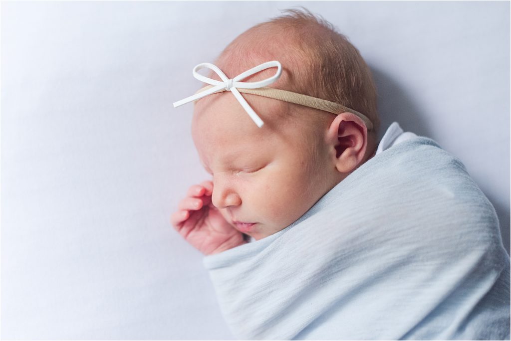 newborn girl with white bow