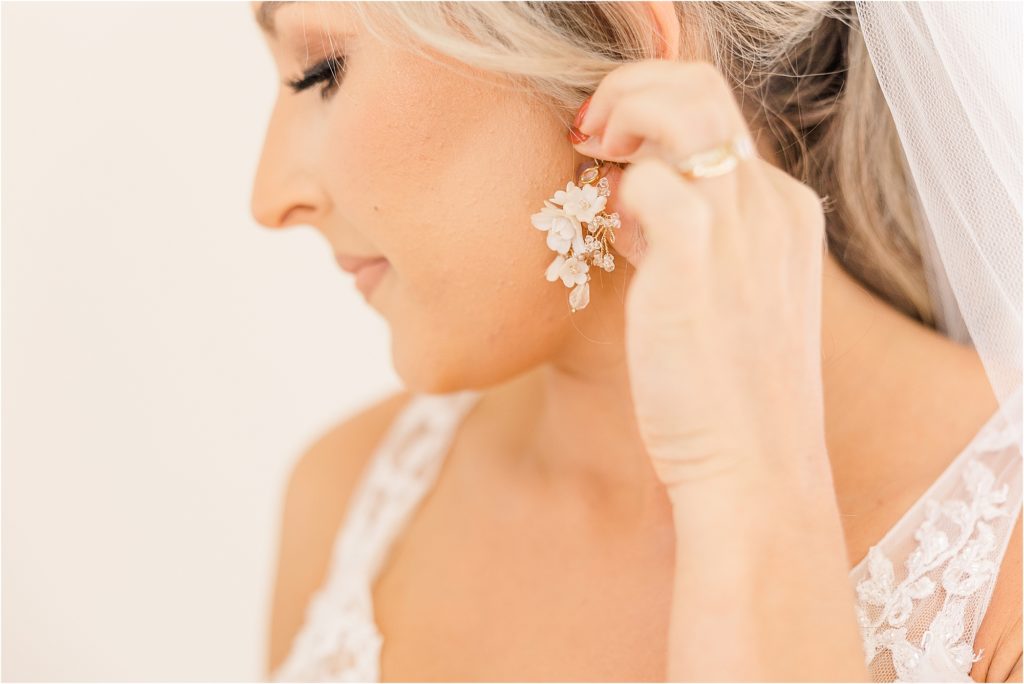 Bride putting on earring Westwind Hills luxury wedding inspiration | Kelsey Alumbaugh Photography | #weddinginspiration #luxurywedding #stlouisweddingphotography #stlwedding #styledshootsacrossamerica