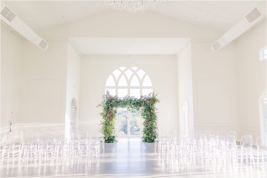 Westwind Hills ceremony with arched windows and greenery at alter Westwind Hills luxury wedding inspiration | Kelsey Alumbaugh Photography | #weddinginspiration #luxurywedding #stlouisweddingphotography #stlwedding #styledshootsacrossamerica
