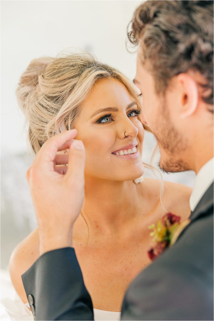Groom brushing hair back from brides face Westwind Hills luxury wedding inspiration | Kelsey Alumbaugh Photography | #weddinginspiration #luxurywedding #stlouisweddingphotography #stlwedding #styledshootsacrossamerica