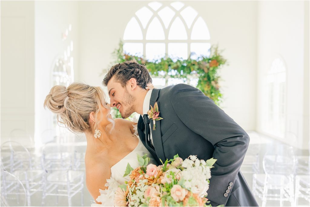 bride in off the shoulder white wedding gown and groom in black tux about to kiss in aisle at Westwind Hills luxury wedding inspiration | Kelsey Alumbaugh Photography | #weddinginspiration #luxurywedding #stlouisweddingphotography #stlwedding #styledshootsacrossamerica