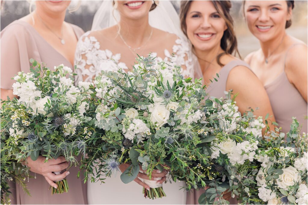 bride with bridesmaids in taupe dresses portraits with white and blue bouquets with tons of greenery at Eagle Bluff Ranch, Waverly, Mo - Haylee + Blake | Missouri River spring wedding | Kansas City wedding photographer | Kelsey Alumbaugh Photogrpahy | #kansascitywedding #missouriweddingphotographer #missourispringwedding