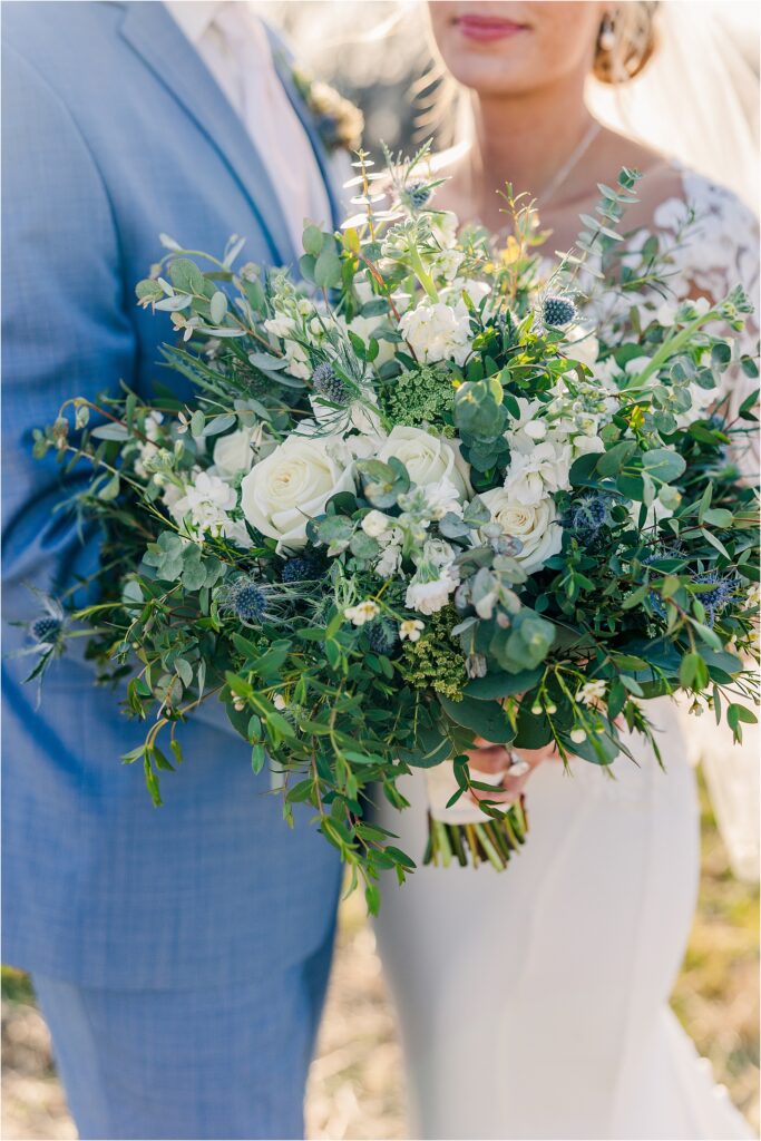 white and blue bridal bouquet during Bride and groom portraits with groom in cornflower blue suits at Eagle Bluff Ranch, Waverly, Mo - Haylee + Blake | Missouri River spring wedding | Kansas City wedding photographer | Kelsey Alumbaugh Photogrpahy | #kansascitywedding #missouriweddingphotographer #missourispringwedding