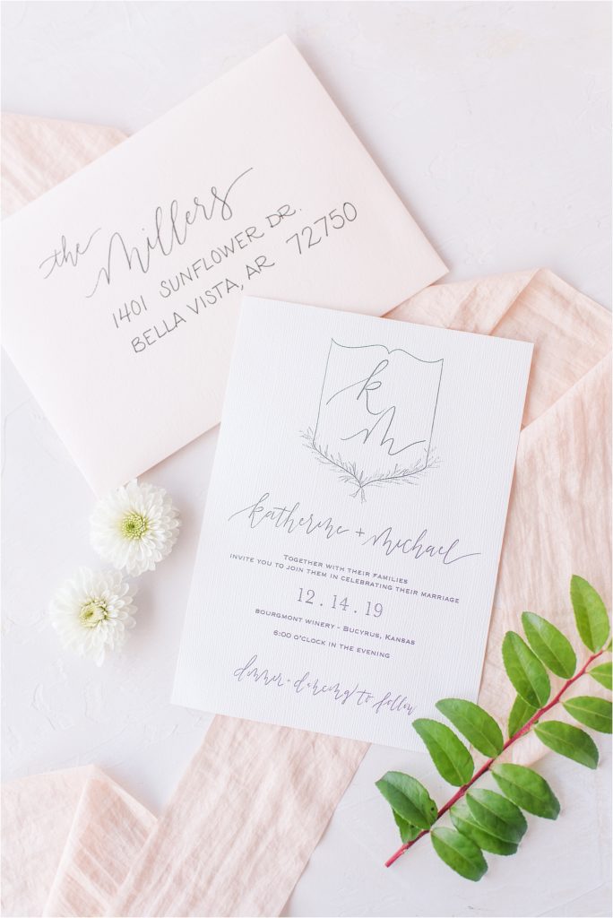 blush and cream wedding invitation with crest 